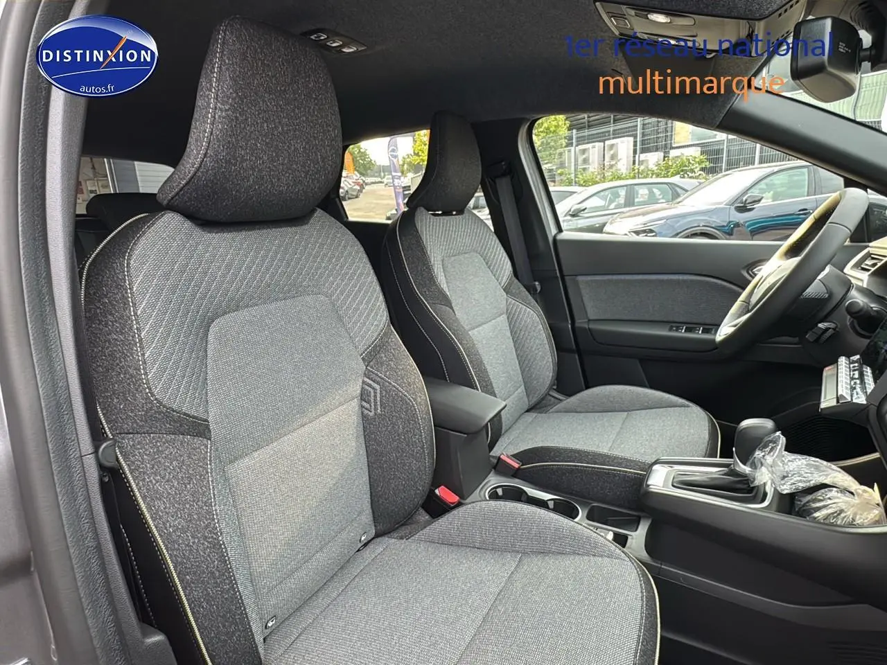 Intérieur avant du Renault Captur gris cassiopée 2025, sièges tissu gris et console centrale avec boîte auto.