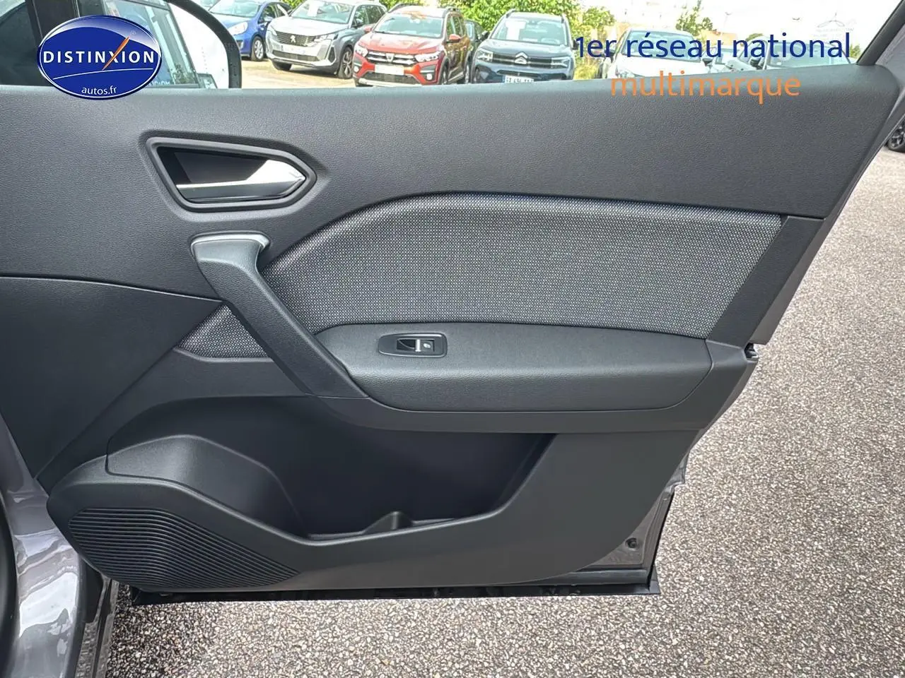 Porte côté gauche ouverte du Renault Captur gris cassiopée, mettant en valeur la garniture intérieure noire et la commande de vitre.