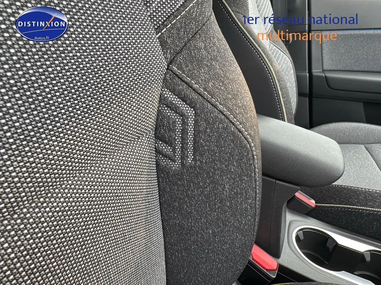 Gros plan sur les sièges avant gris cassiopée et accoudoir central du Renault Captur 2025 hybride.