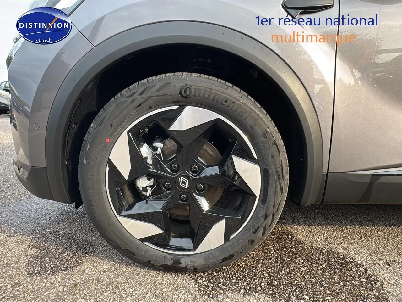 Gros plan sur la roue avant gauche du Renault Captur gris cassiopée avec jante alu noire et argentée au design étoilé.