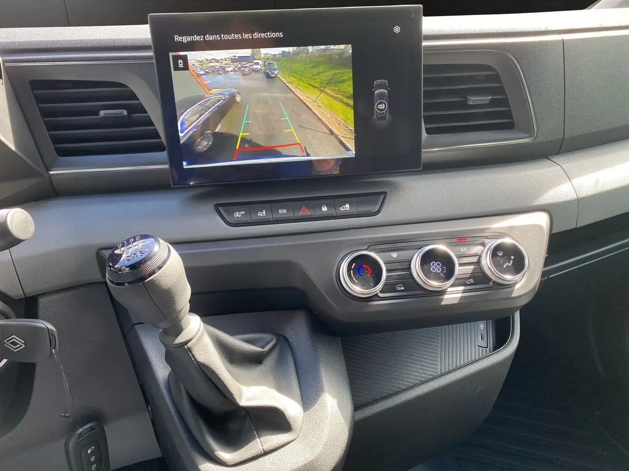 Vue rapprochée de la console centrale du Renault Master 2025 avec écran caméra de recul et commandes climatisation.