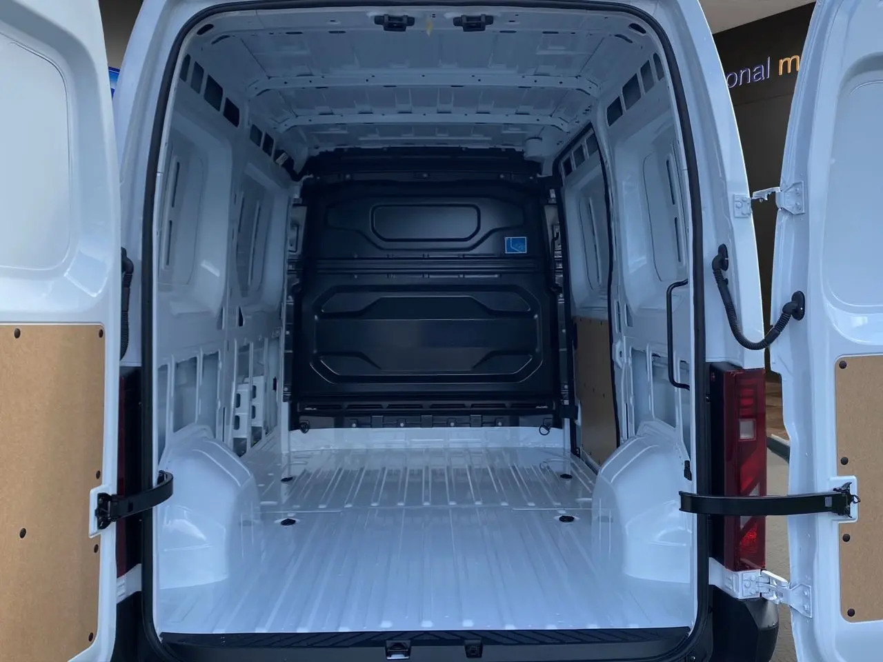 Intérieur du Renault Master blanc 2025 vu de l’arrière avec portes ouvertes et espace de chargement vide et tôlé.