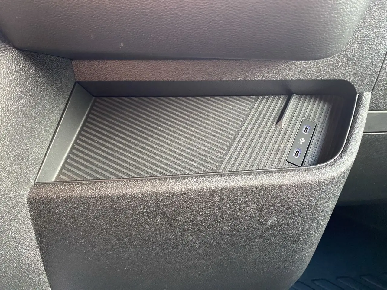 Gros plan sur la console centrale du Renault Master blanc 2025, avec un espace de rangement et deux ports USB visibles.