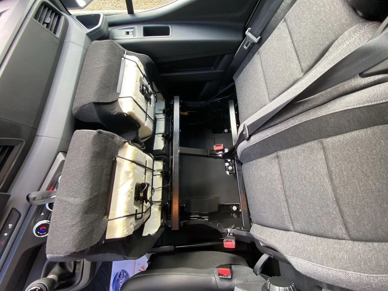 Vue intérieure rapprochée de la banquette passager en tissu gris foncé du Renault Master 2025 avec dossiers relevés.