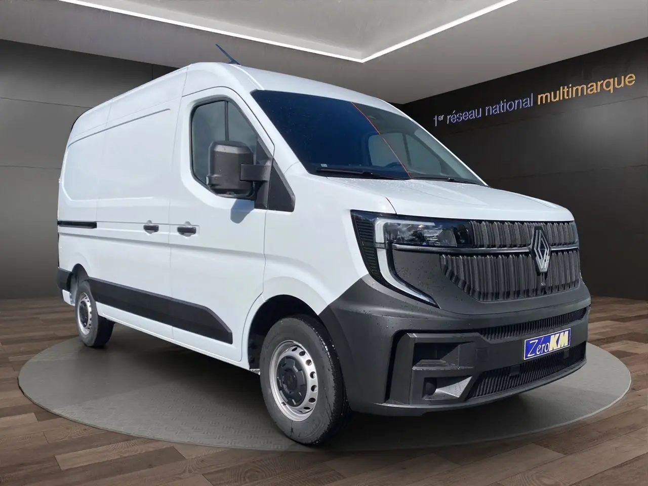 Vue 3/4 avant d'un Renault Master blanc avec calandre noire grainée et jantes tôlées 16 pouces en showroom.