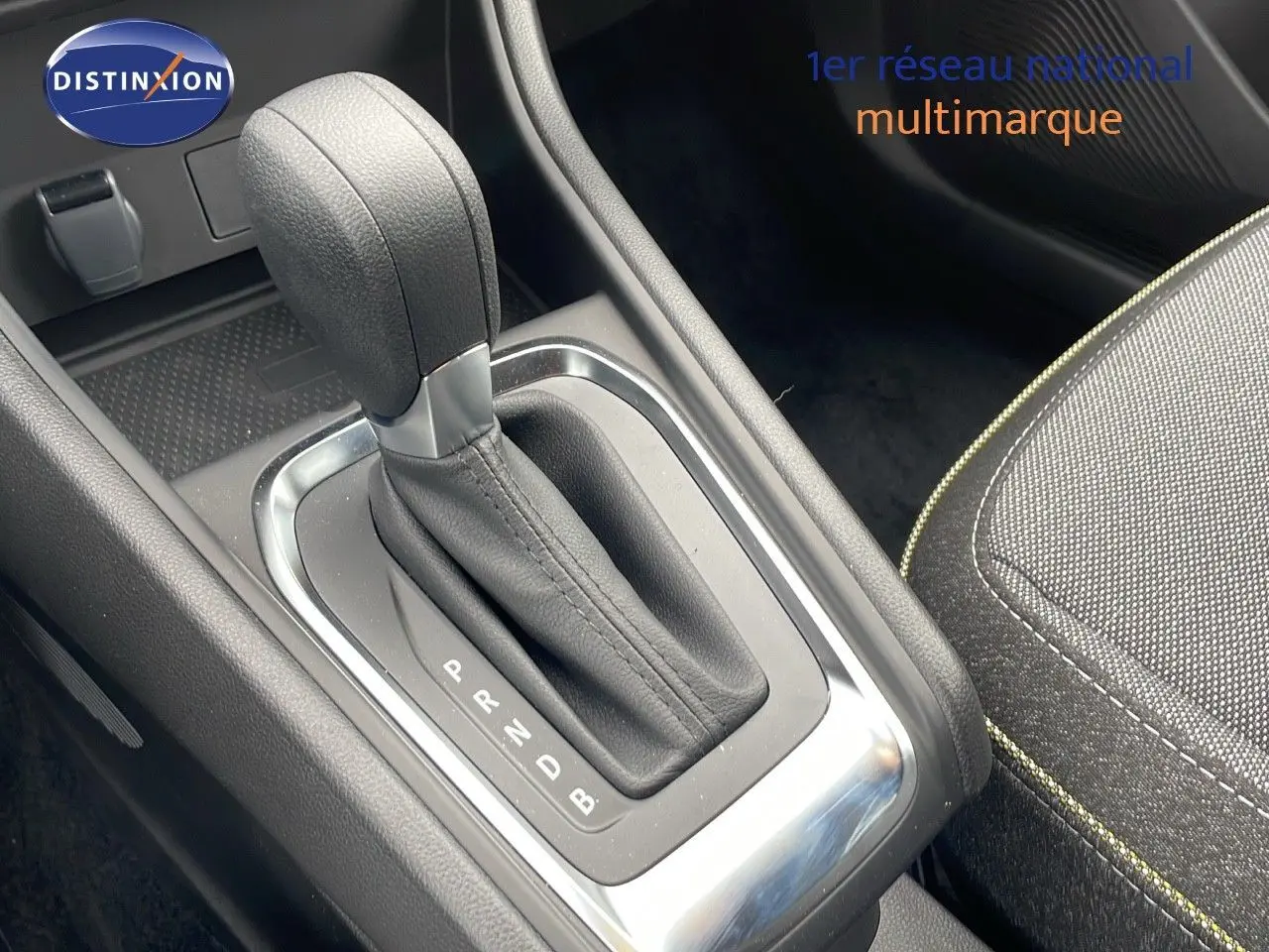 Le levier de vitesses automatique en cuir noir de la Renault Captur E-Tech Hybrid 2025, avec partie centrale et siège tissu gris.