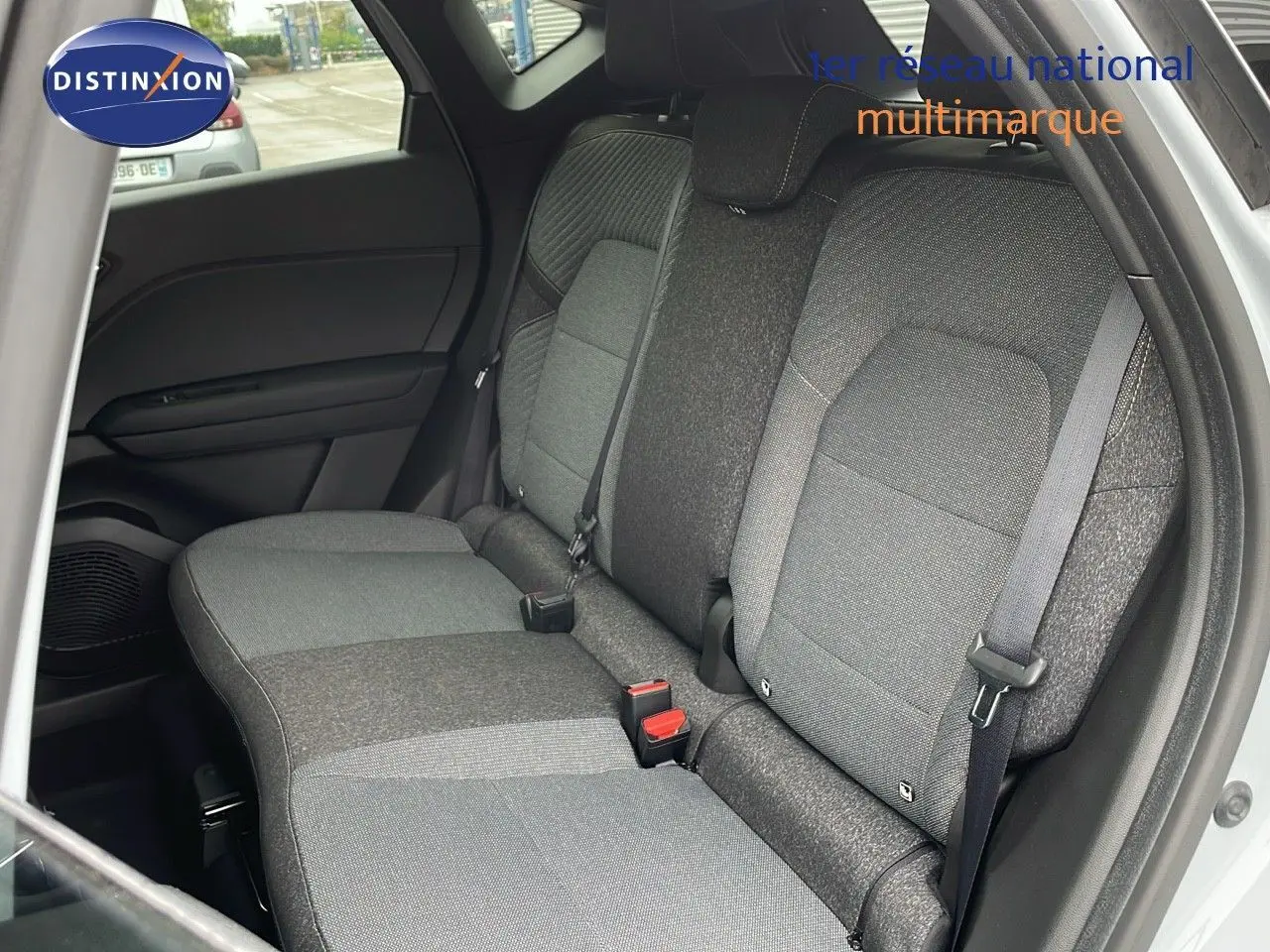 Vue intérieure sur la banquette arrière gris foncé du Renault Captur E-Tech 2025 avec ceintures de sécurité visibles.