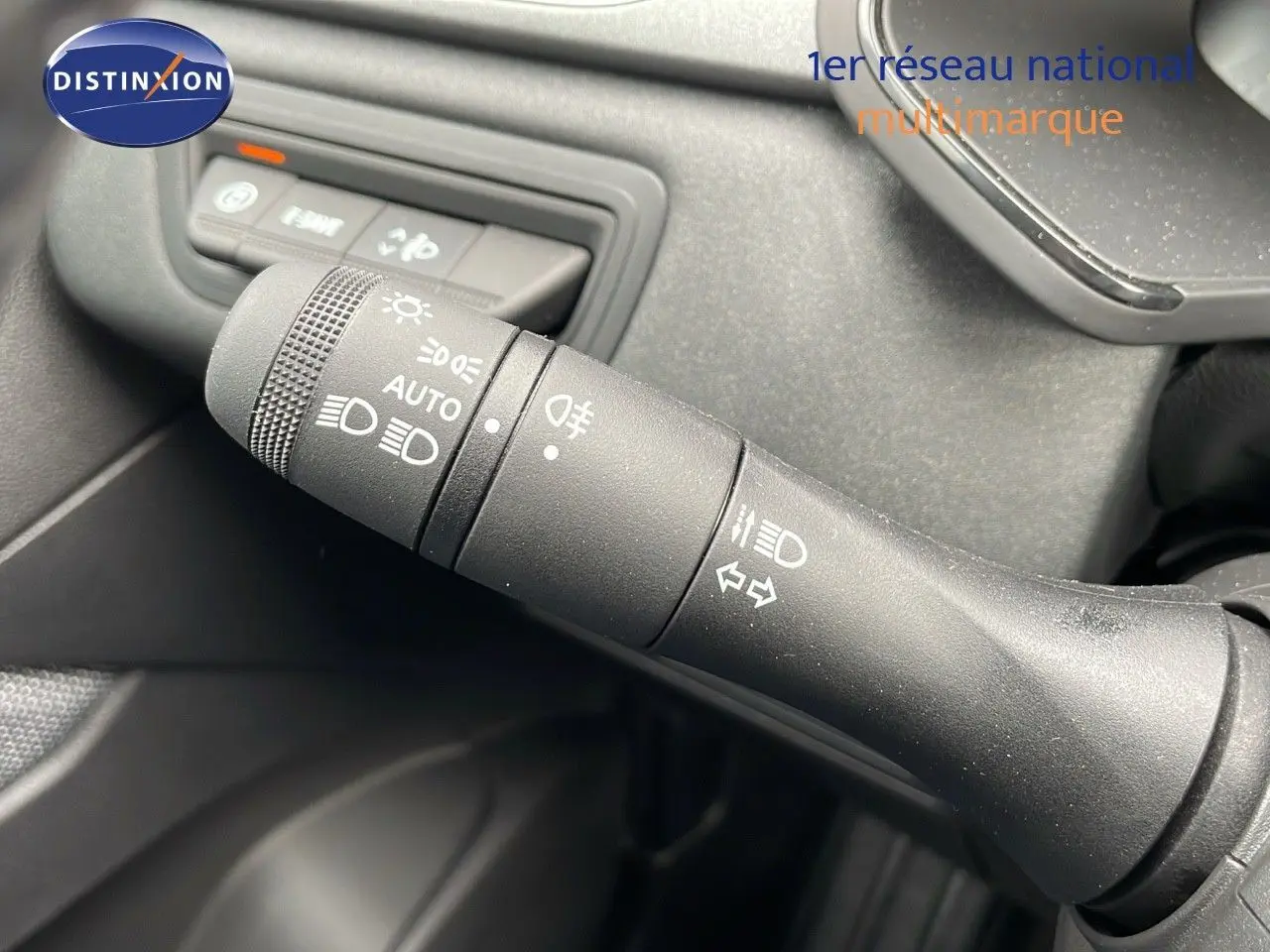 Gros plan sur la commande des feux et clignotants du Renault Captur gris rafale, intérieur noir.