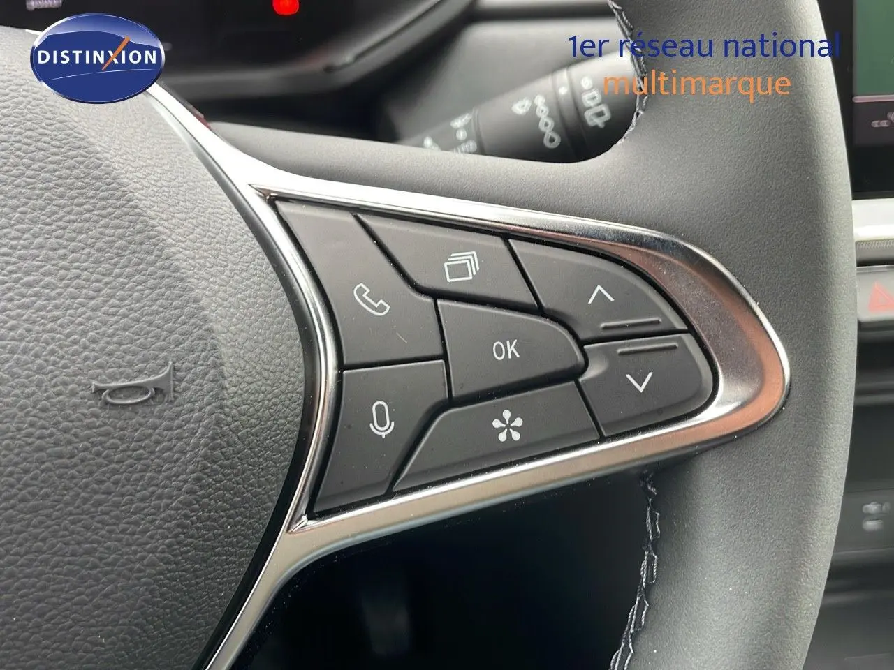 Gros plan sur les commandes multifonctions à gauche du volant du Renault Captur gris Rafale 2025 avec finition Technno.