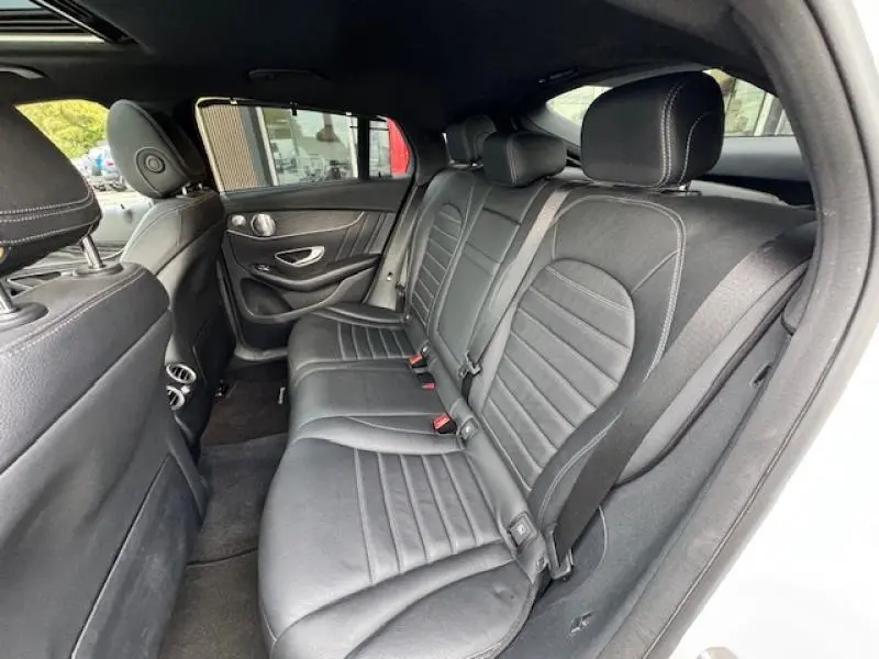 Vue intérieure côté droit des sièges arrière en cuir noir du Mercedes GLC Coupé blanc polaire avec finitions élégantes.