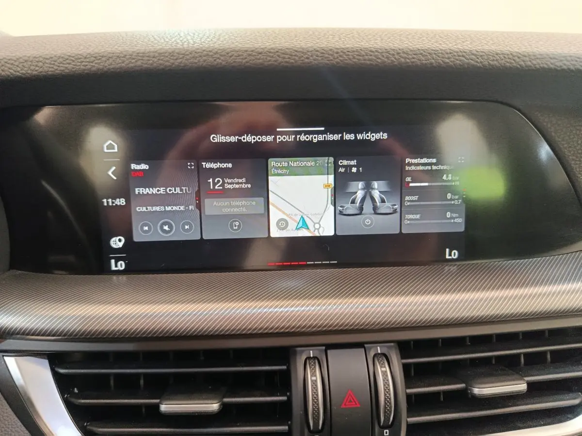 Écran tactile central 22,4 pouces de l'Alfa Romeo Stelvio 2024, tableau de bord avec finition carbone grise.