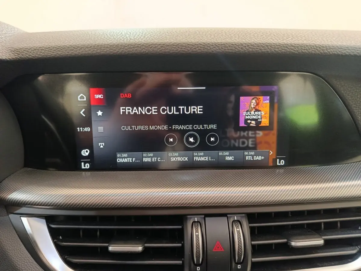 Écran tactile central affichant la radio DAB France Culture dans l'habitacle d'un Alfa Romeo Stelvio gris foncé.