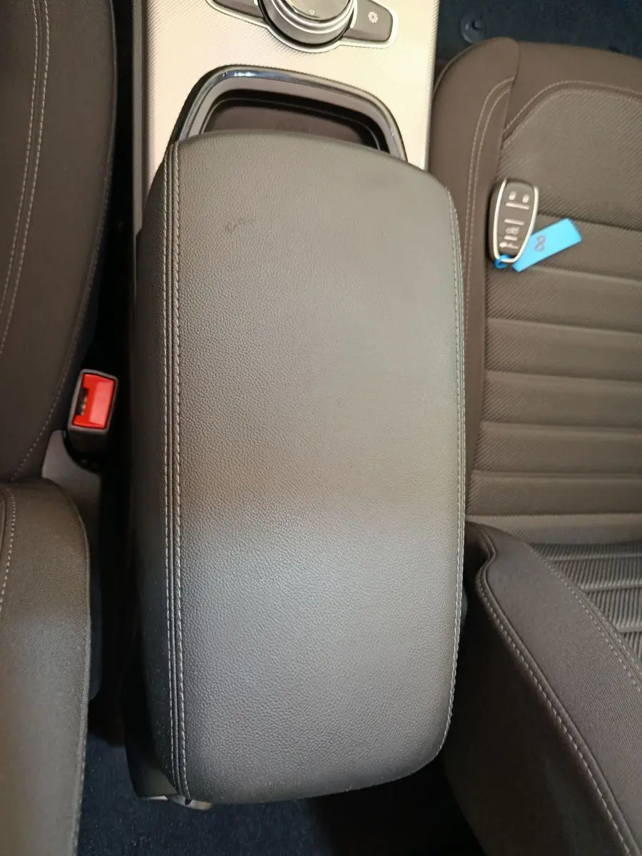 Vue plongeante sur l'accoudoir central en cuir noir et siège tissu gris foncé avec clé de voiture Alfa Romeo Stelvio.