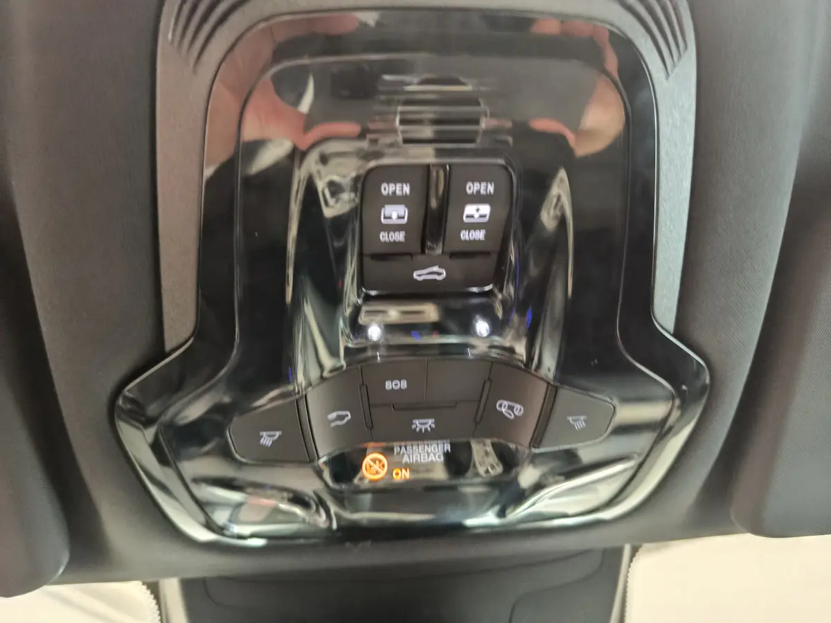 Gros plan sur les commandes de toit ouvrant et éclairage intérieur noir brillant dans un Alfa Romeo Stelvio gris foncé 2024.