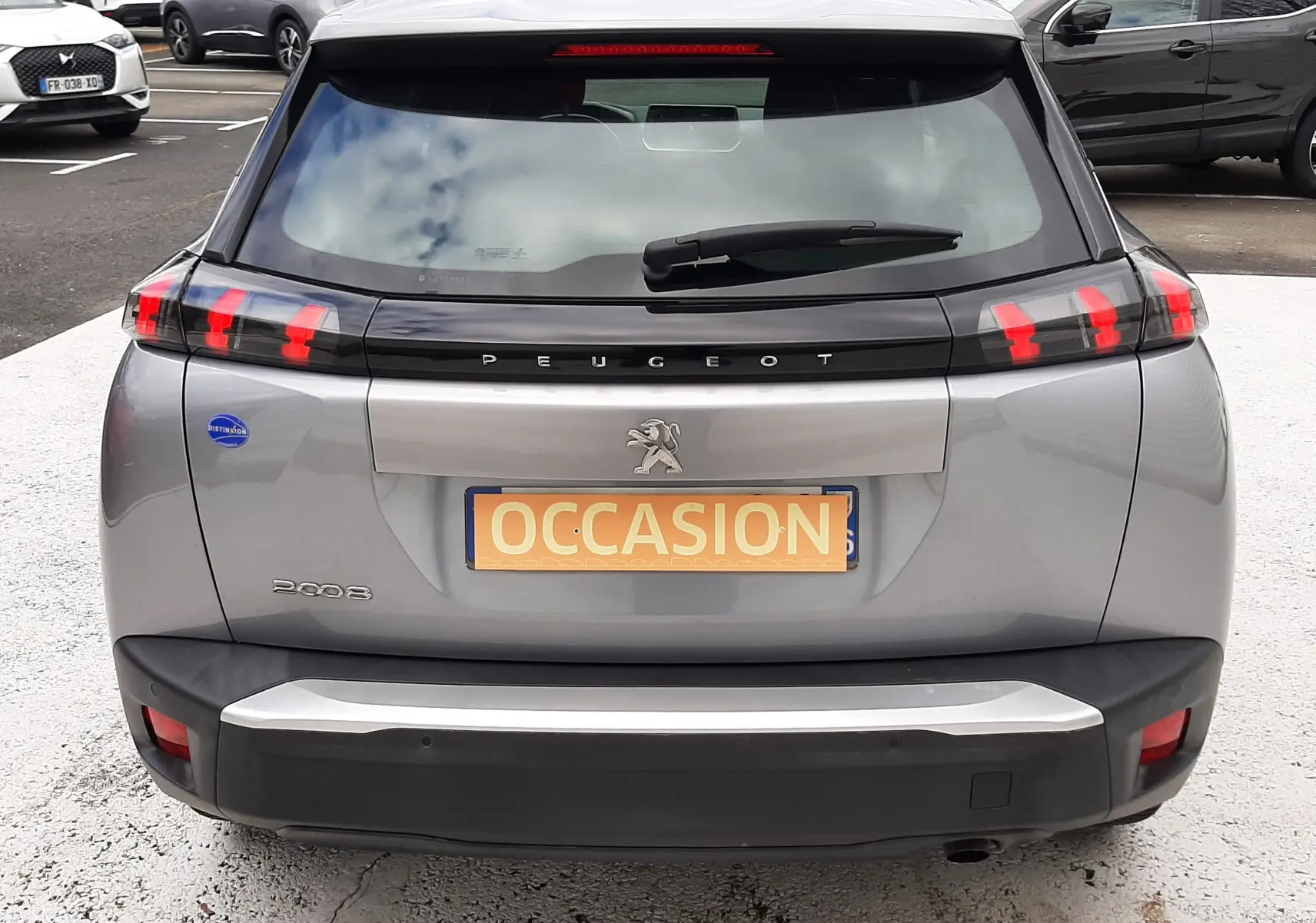 Vue arrière d'un Peugeot 2008 gris Artense avec feux LED caractéristiques et plaque "OCCASION" visible.
