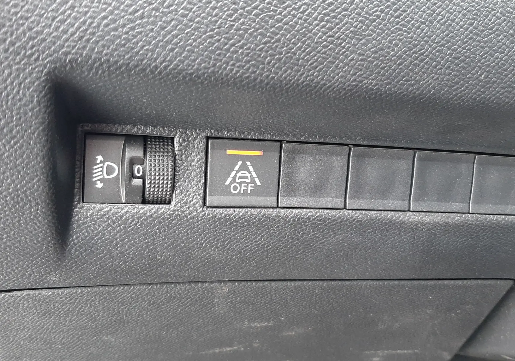 Gros plan sur les commandes noires du tableau de bord du Peugeot 2008 gris Artense, avec bouton d'alerte de maintien de voie désactivé.