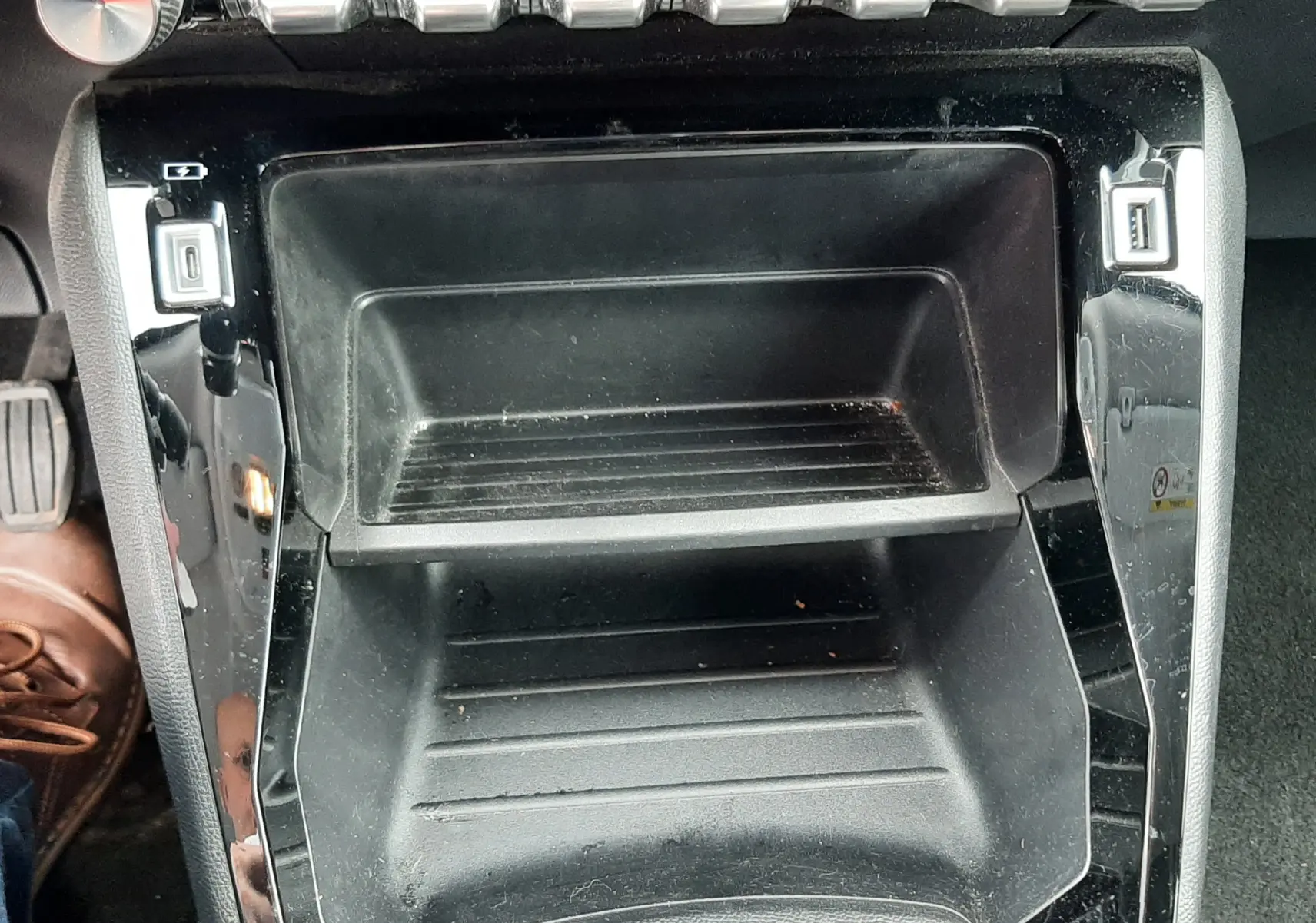 Vue rapprochée de la console centrale noire du Peugeot 2008 1.5 BlueHDi 2020 avec boutons de commande et ports USB visibles.