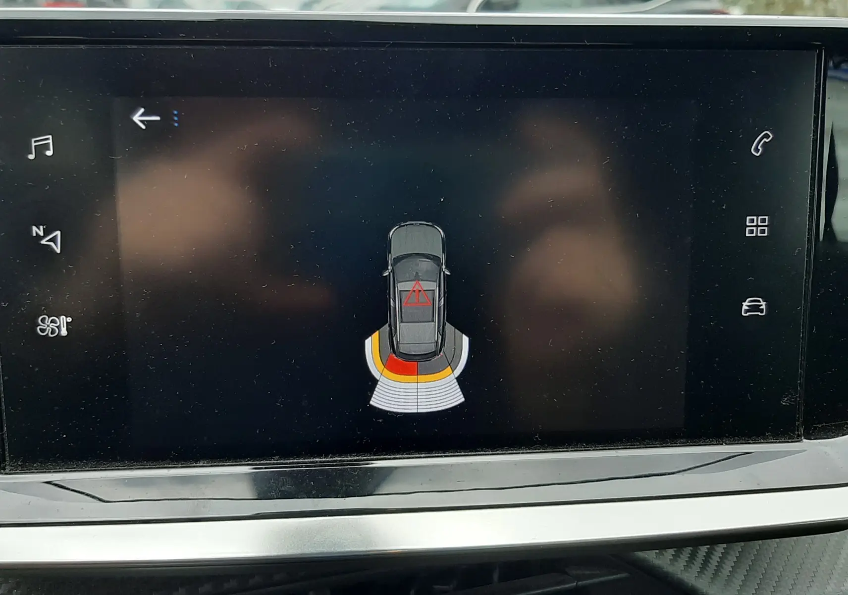 Écran de la Peugeot 2008 1.5 BlueHDi 2020 montrant l'alerte de proximité arrière avec signalisation en rouge et orange.