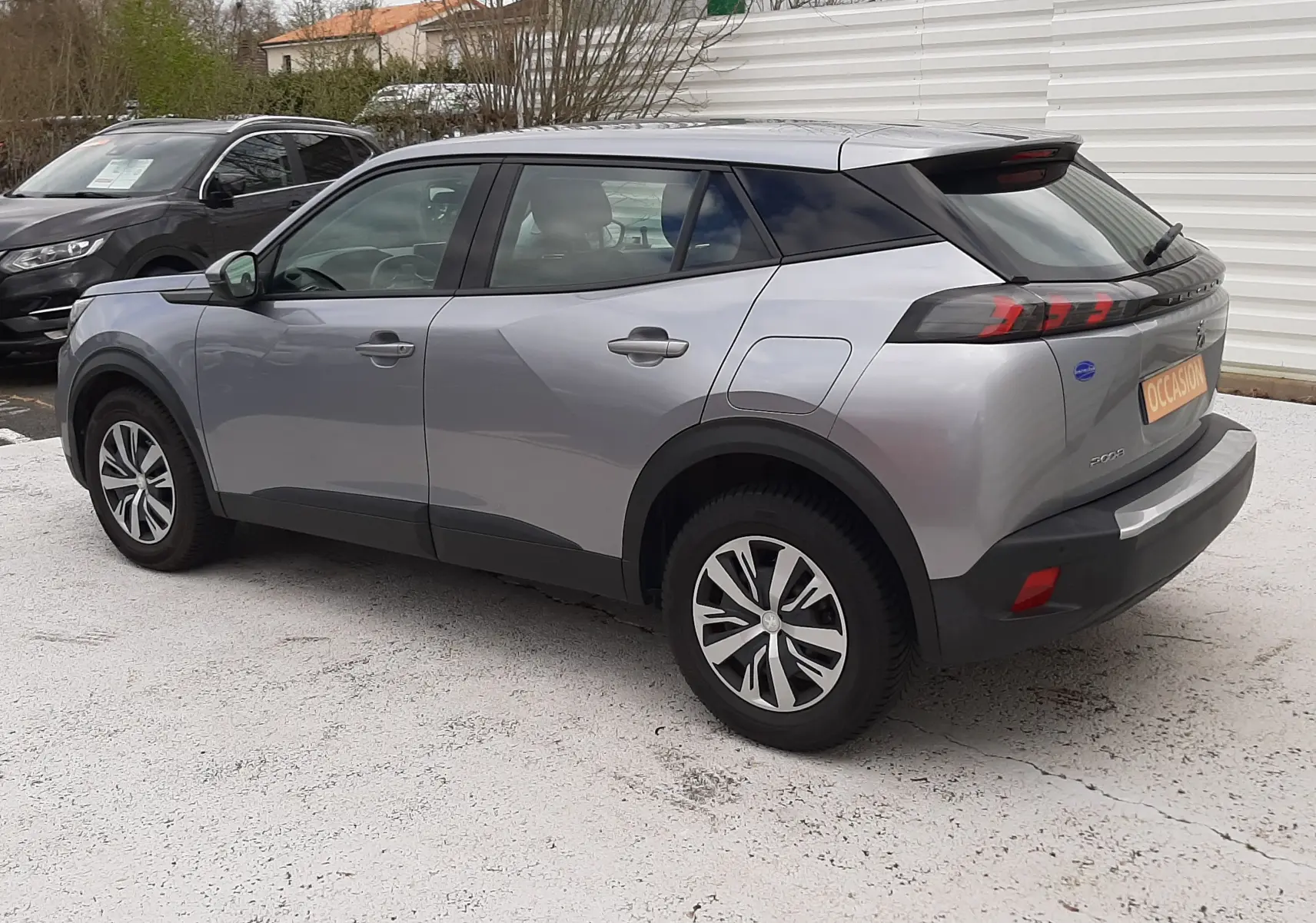 Peugeot 2008 gris Artense vue 3/4 arrière droit, SUV compact avec feux arrière à LED et jantes alliage.