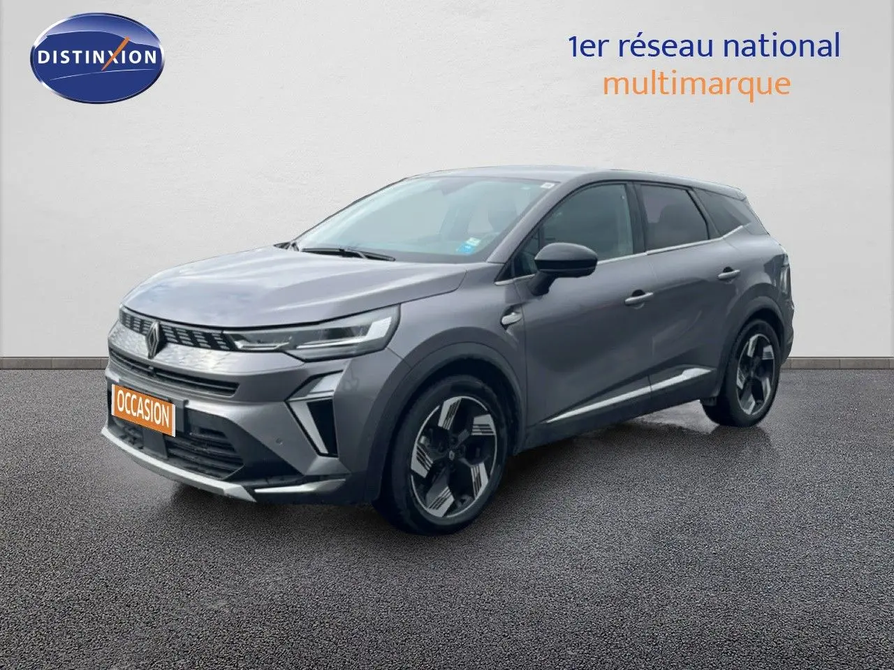 Renault Symbioz gris cassiopée métal en 3/4 avant droit, SUV hybride avec jantes bi-ton et calandre moderne.
