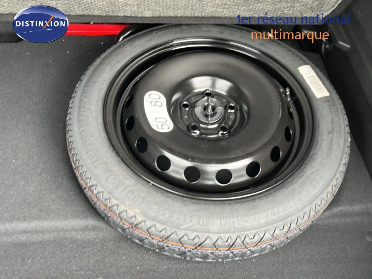 Roue de secours noire vue de dessus dans le coffre d’une Renault Symbioz gris cassiopée métal 2025.