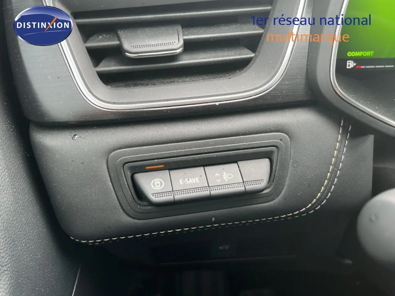 Gros plan sur les commandes E-SAVE et réglage des phares dans l’habitacle noir du Renault Symbioz gris cassiopée 2025.