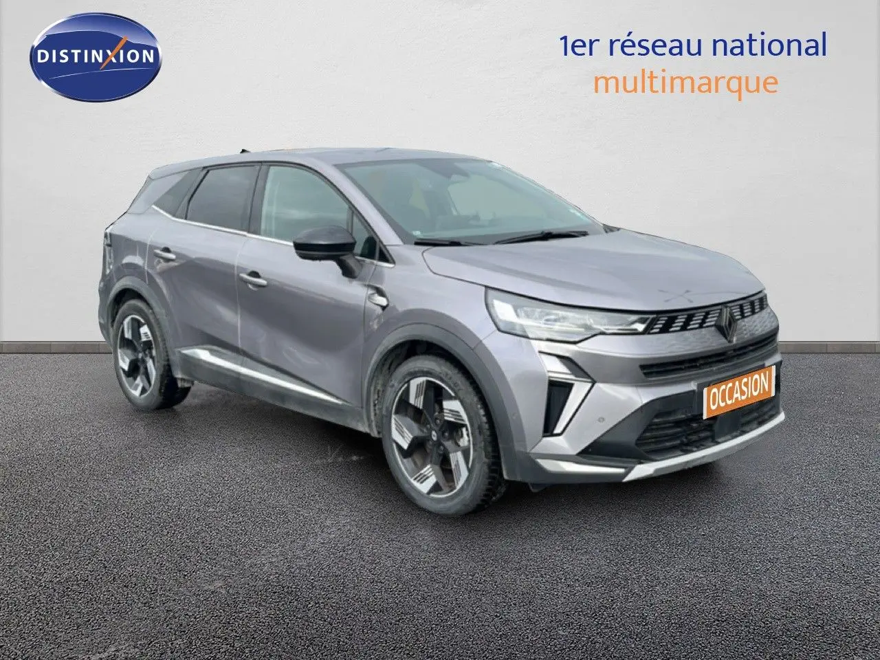 Vue 3/4 avant droit d'un Renault Symbioz 2025 gris cassiopée métal avec calandre moderne et jantes stylisées.