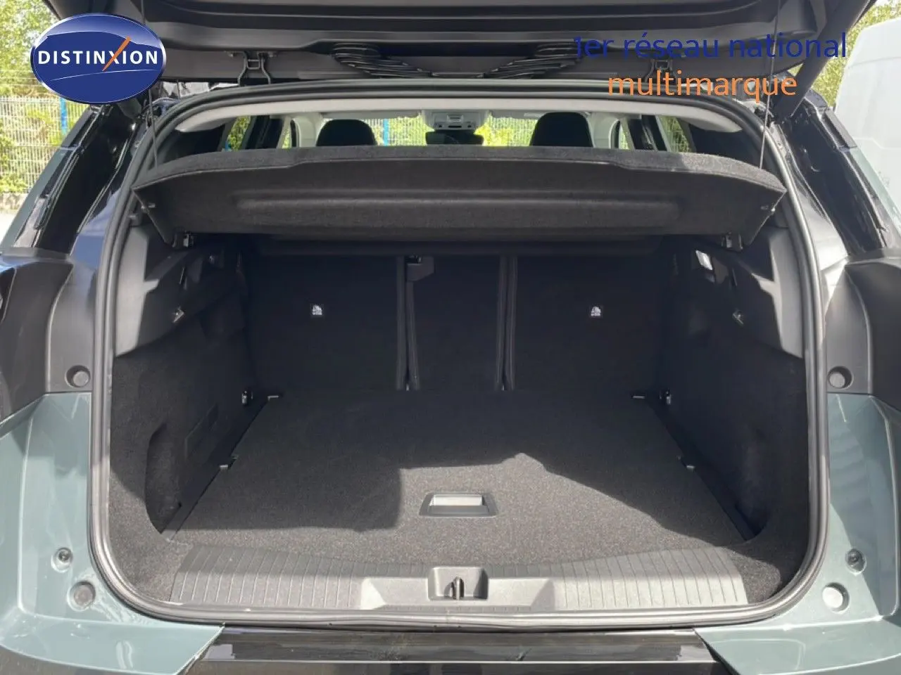 Coffre ouvert vu de l'arrière du Citroën C5 Aircross Hybrid 2026 en vert Astoria Metal, espace de chargement spacieux et propre.