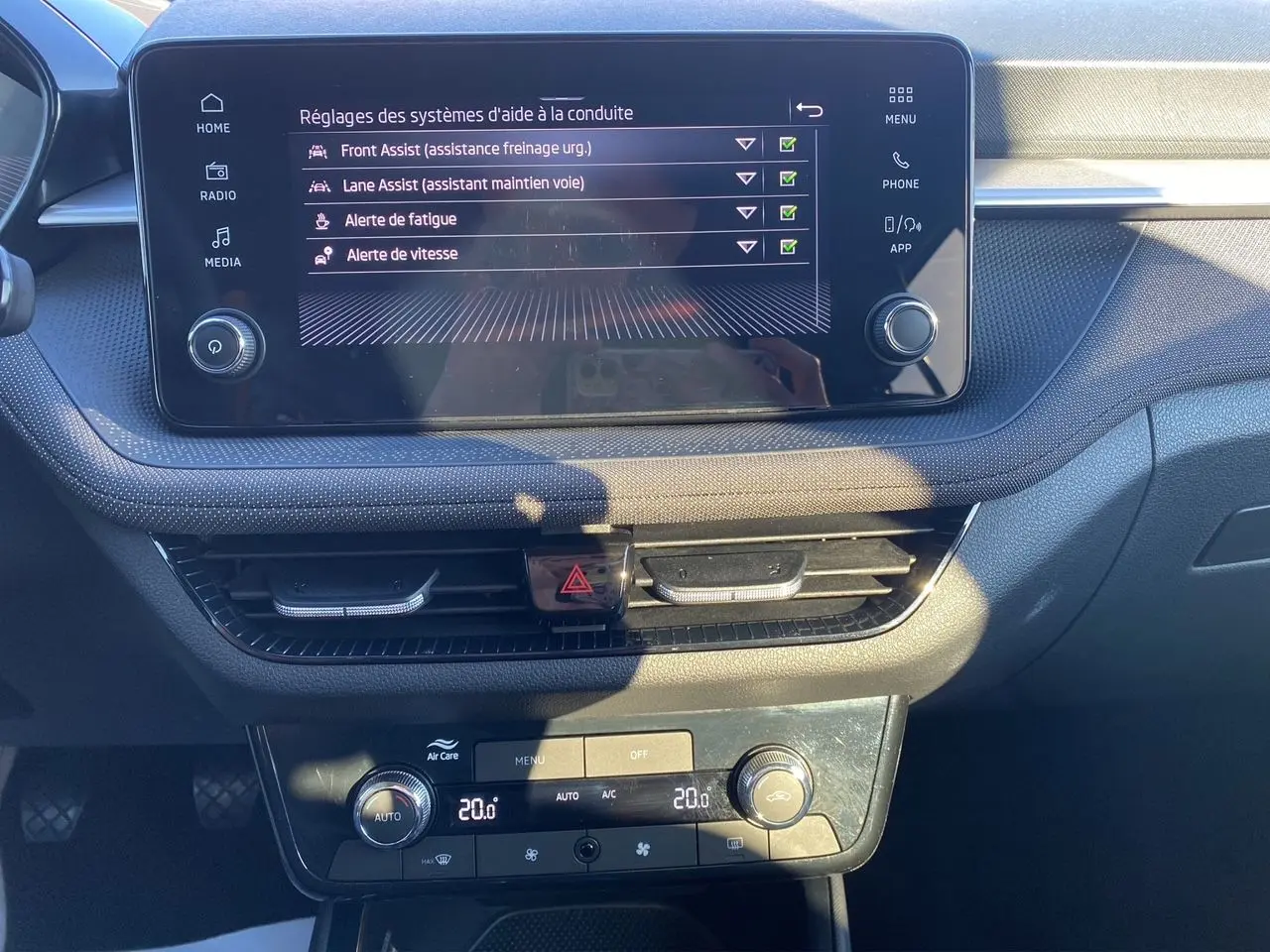 Vue rapprochée du tableau de bord de la Skoda Fabia 2024, écran tactile et commandes de climatisation visibles.