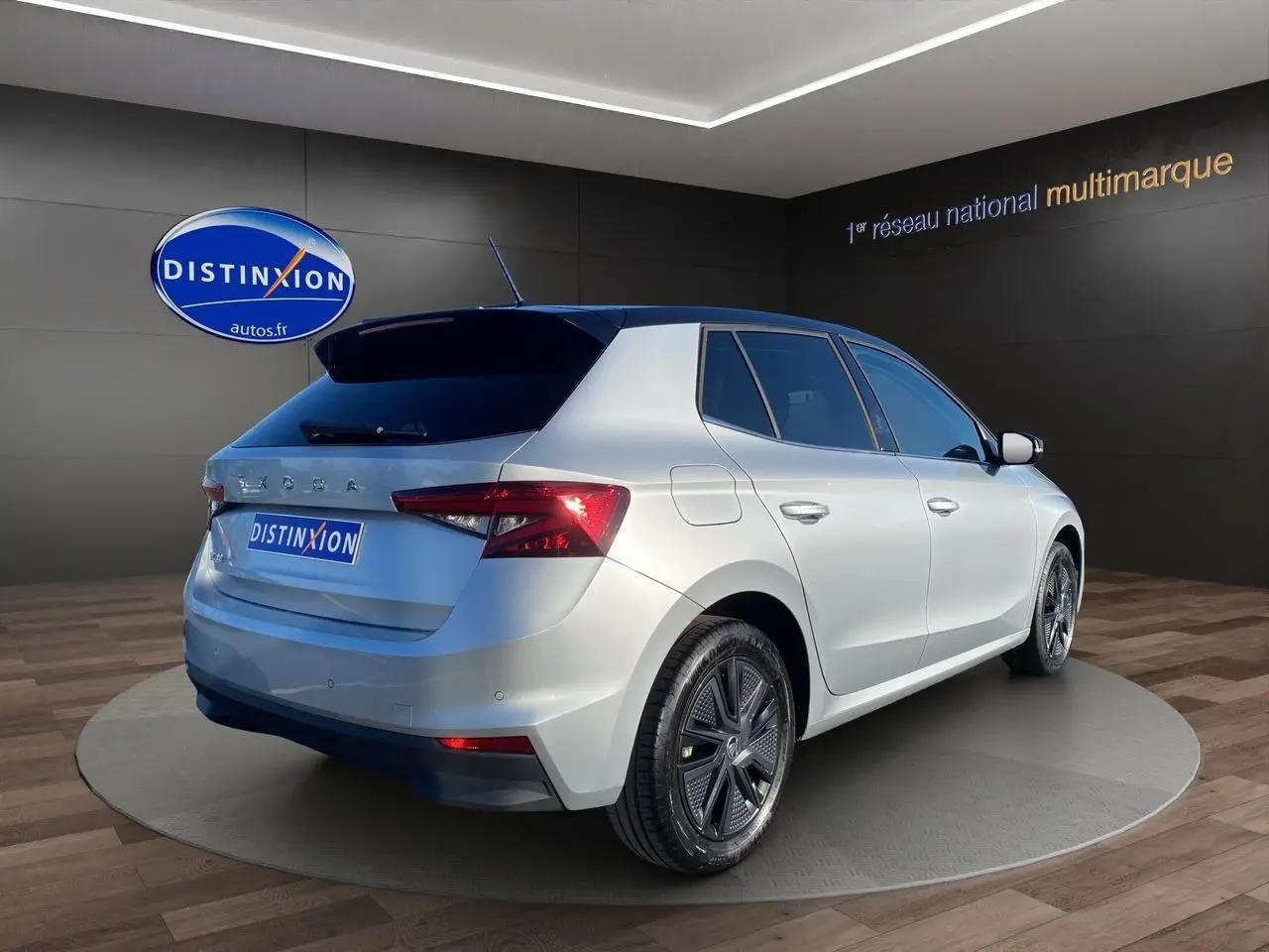 Vue 3/4 arrière droite d'une Skoda Fabia 2024 gris clair avec toit noir et jantes modernes en concession.