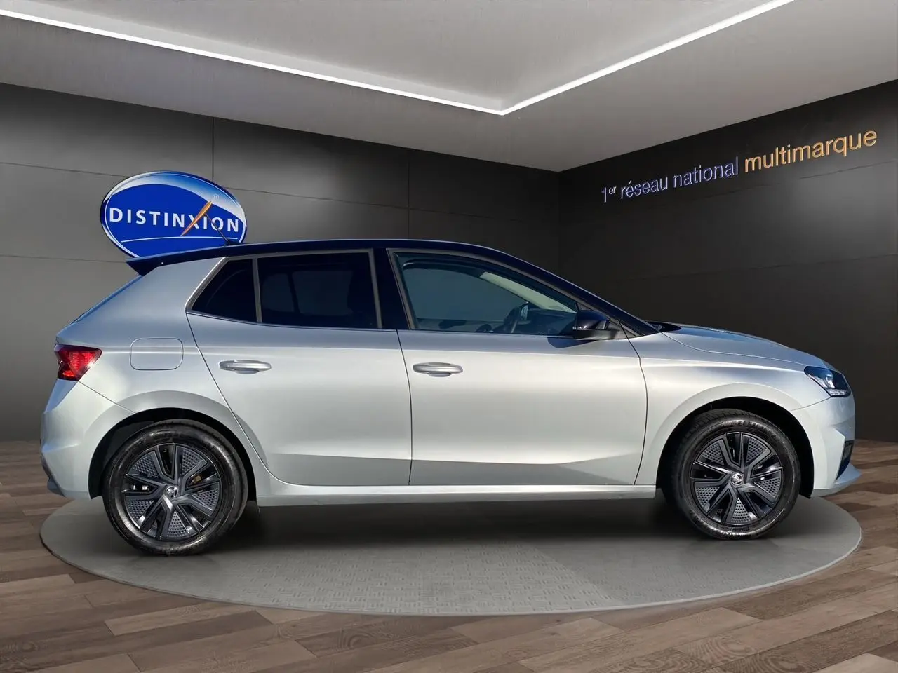 Profil droit d'une Skoda Fabia 1.0 TSI EVO 95 Style 2024 en gris clair avec toit noir et jantes modernes.