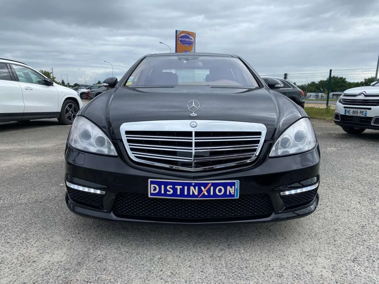 Mercedes Classe S 600 L noire vue de face, avec calandre chromée et feux LED diurnes allumés.