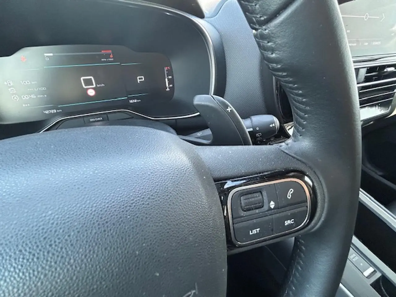 Gros plan sur le volant noir et le tableau de bord numérique du Citroën C5 Aircross 2022, version essence Gris Platinium.