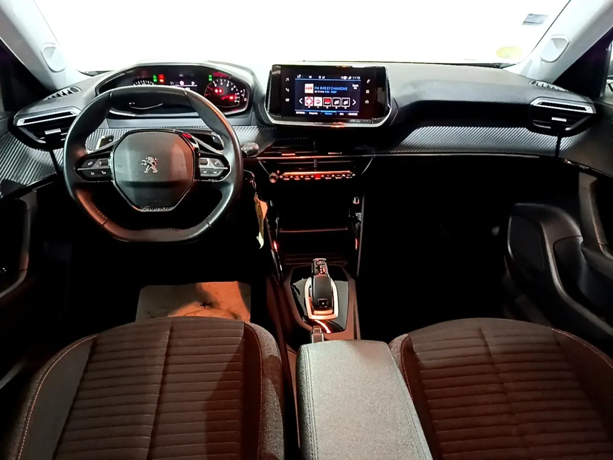 Vue intérieure avant du Peugeot 2008 2021, tableau de bord noir avec volant cuir multifonctions et écran tactile central.
