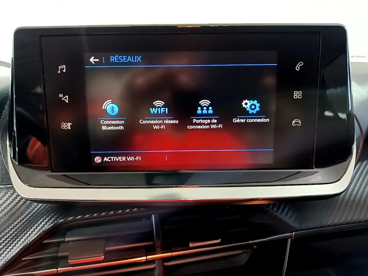 Écran tactile central du tableau de bord du Peugeot 2008 gris clair, affichant les options de connexion réseau Wi-Fi et Bluetooth.