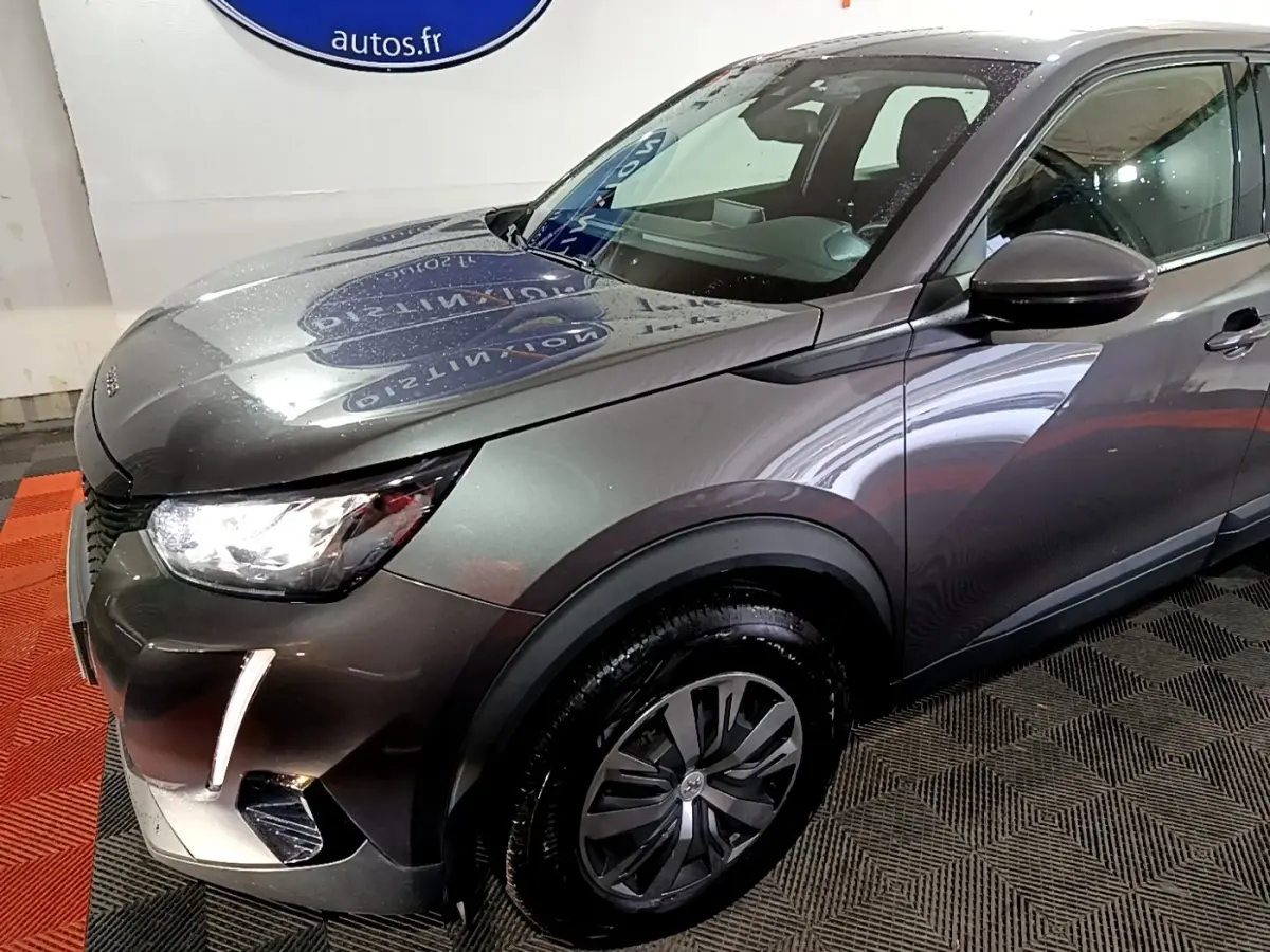 Vue 3/4 avant droit d'un Peugeot 2008 gris clair avec feux LED et jantes alliage distinctives.