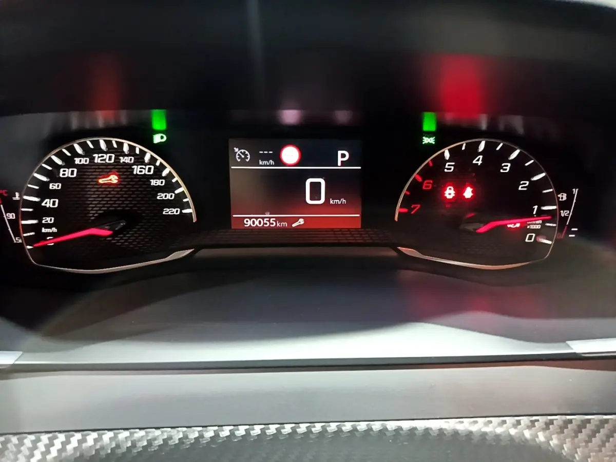 Tableau de bord numérique du Peugeot 2008 gris clair, affichage vitesse à 0 km/h et compteur kilométrique à 90055 km.