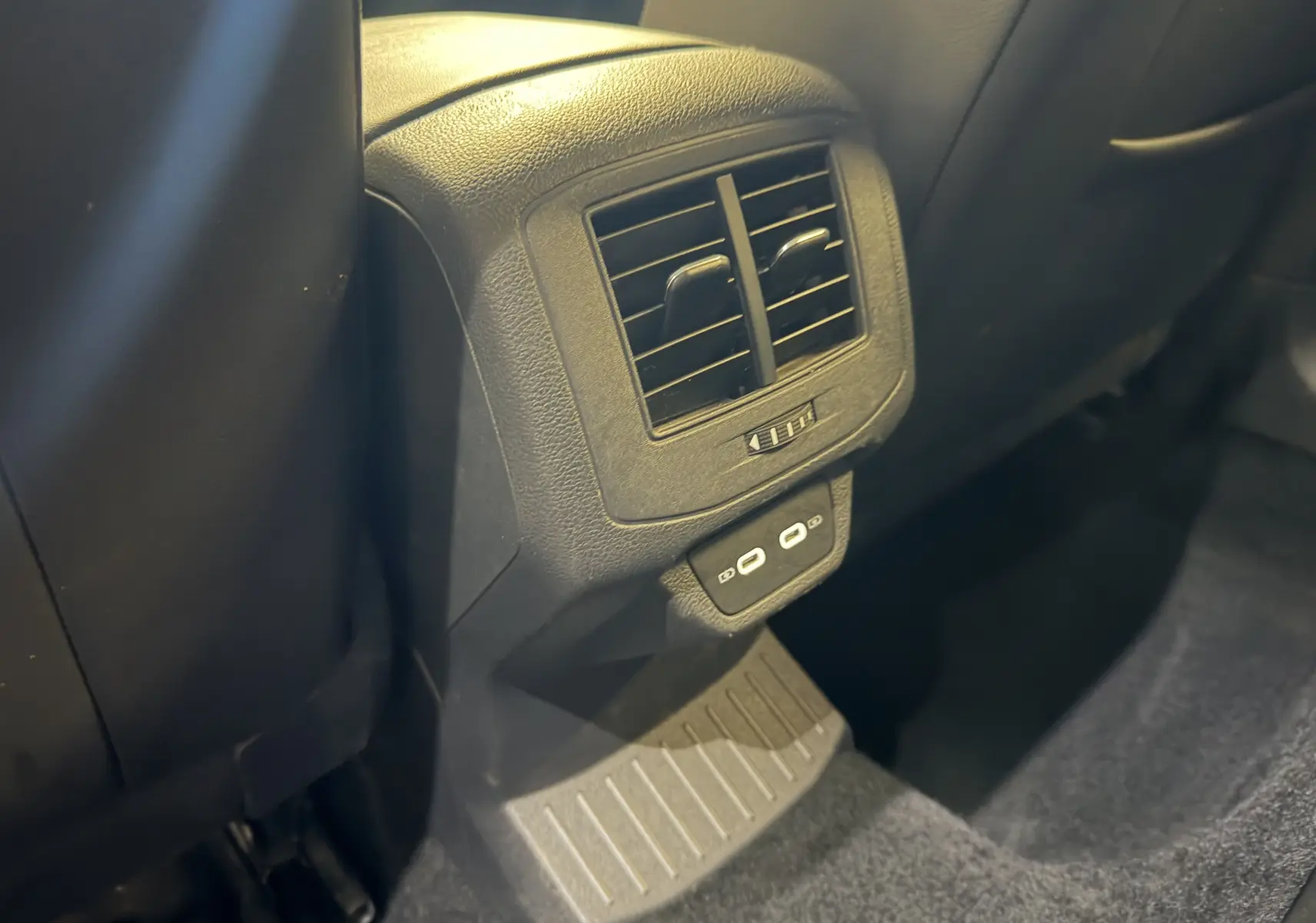 Détail de la console arrière noire du Volkswagen T-Roc 2022 avec bouches d’aération et ports USB visibles.