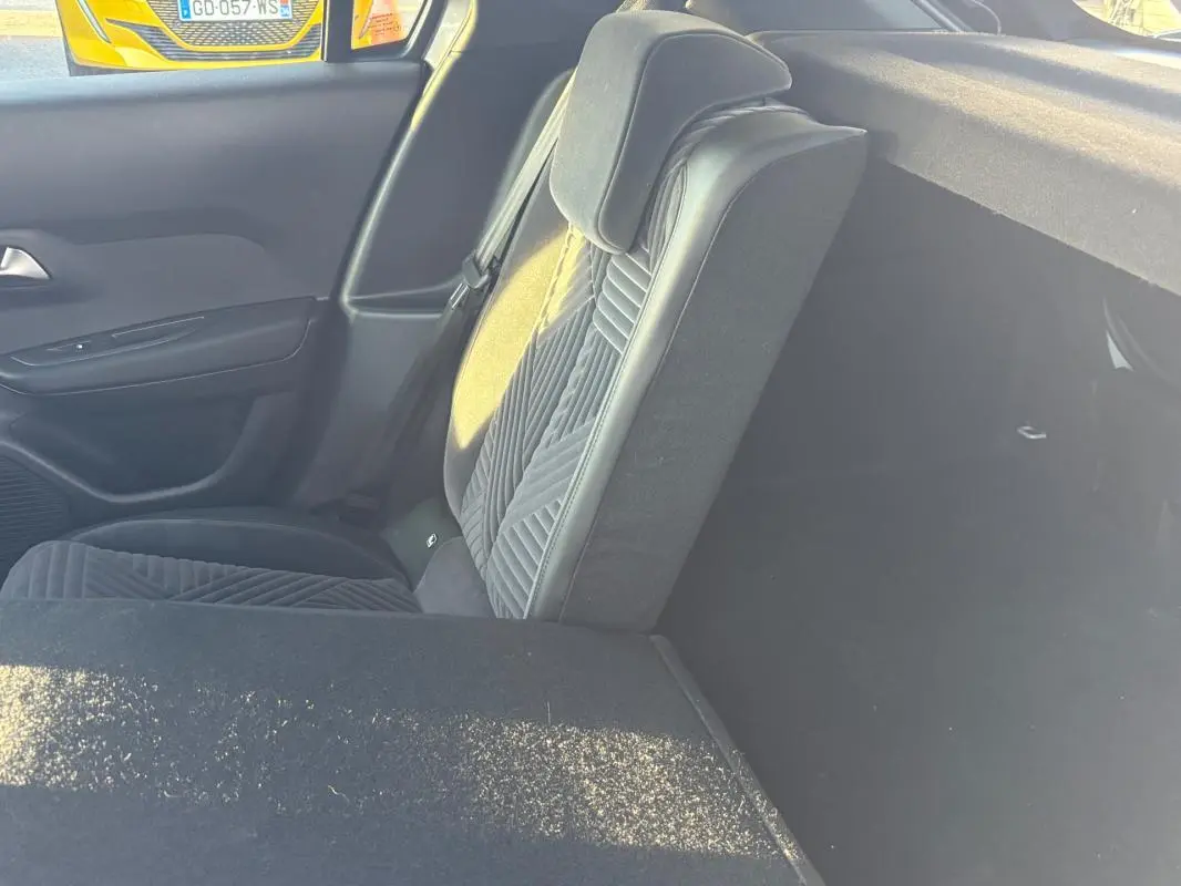 Vue intérieure côté droit montrant le siège arrière rabattable en tissu gris de la Lancia Ypsilon 2025.