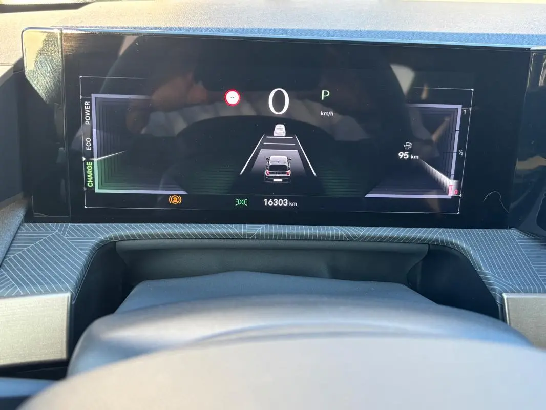 Tableau de bord numérique de la Lancia Ypsilon 1.2 Ibrida 2025, affichant la vitesse et l'autonomie, vue de face.