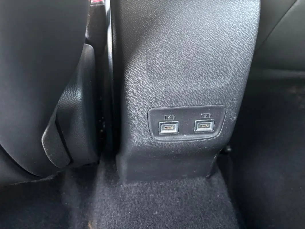 Vue rapprochée des ports USB arrière sur la console centrale d'une Lancia Ypsilon gris 2025.