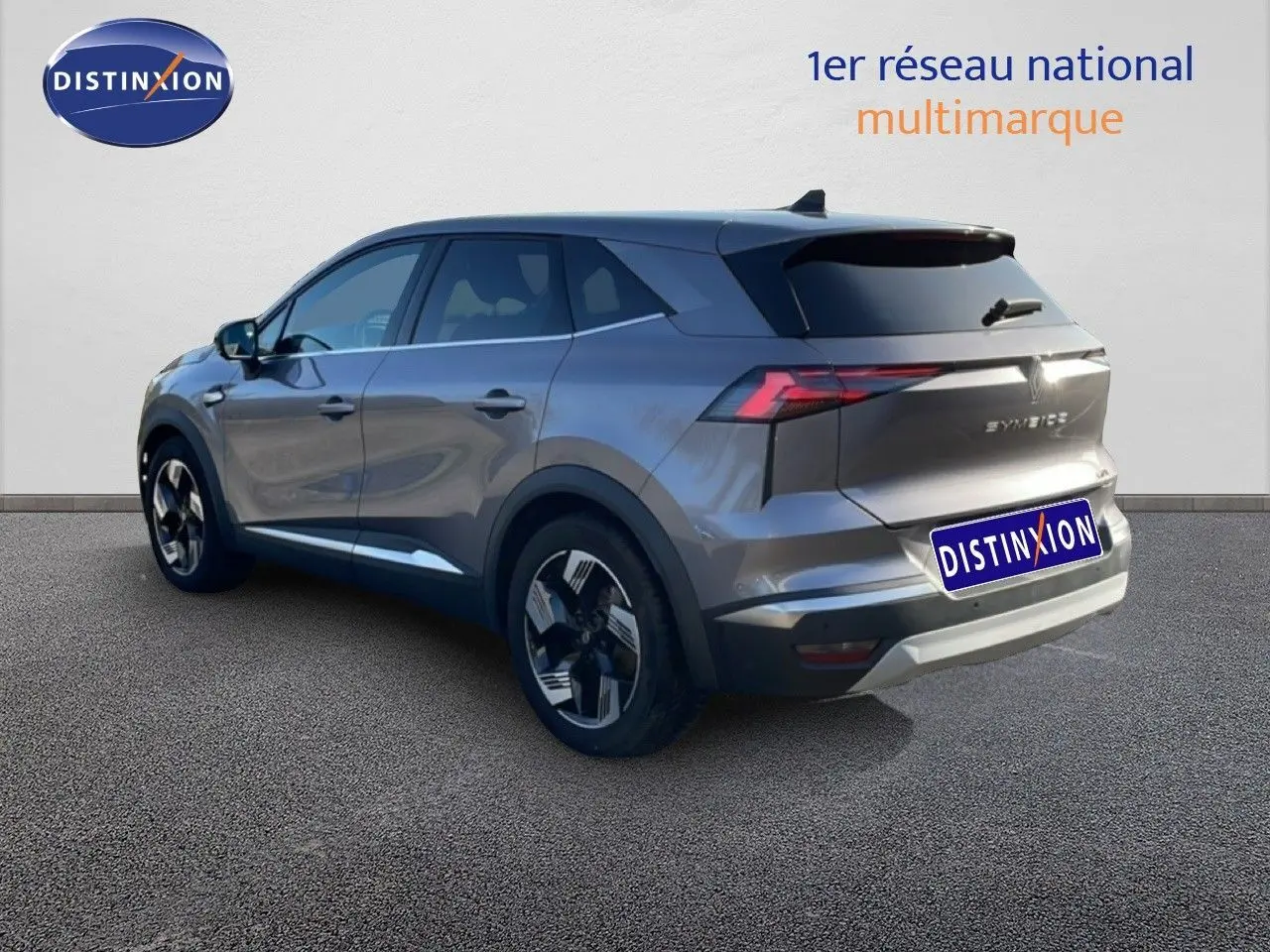 Renault Symbioz gris cassiopée métal en 3/4 arrière droit, SUV hybride avec feux arrière LED et jantes bicolores.
