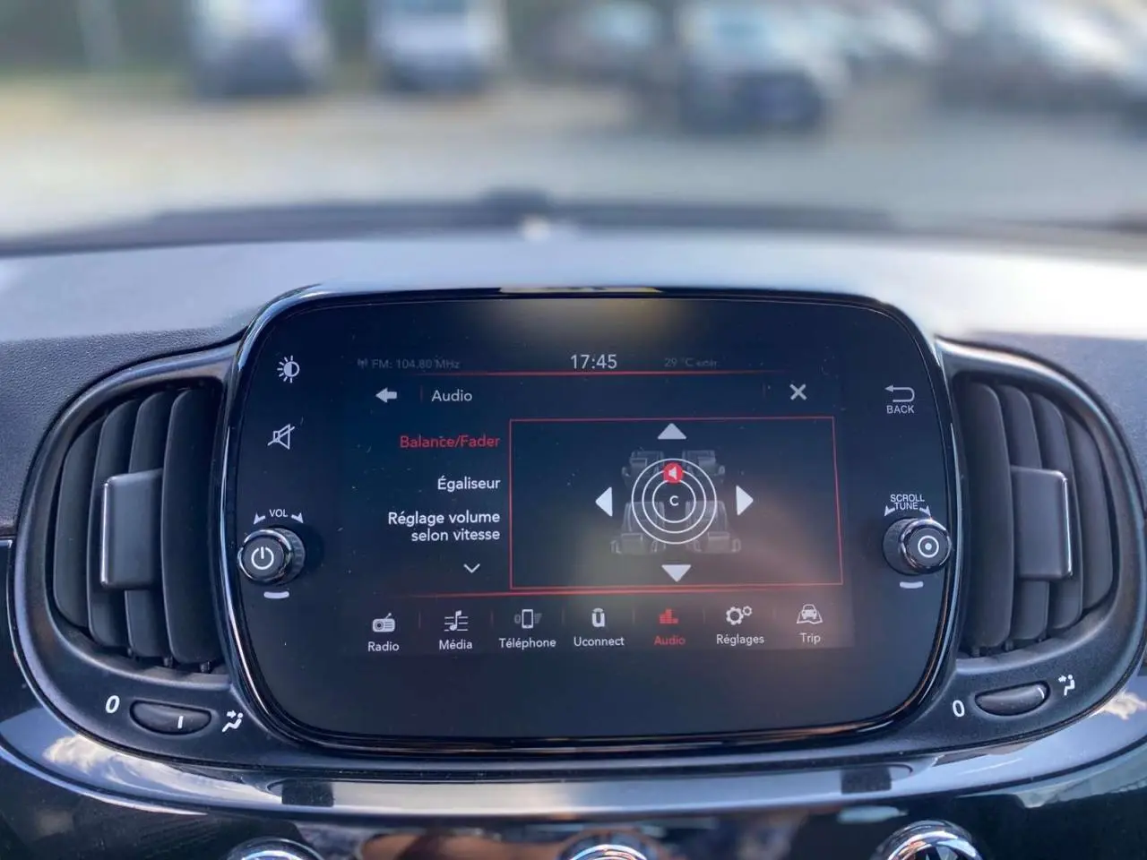 Écran tactile central du tableau de bord de la FIAT 500 noire 2024 affichant les réglages audio et volume selon vitesse.