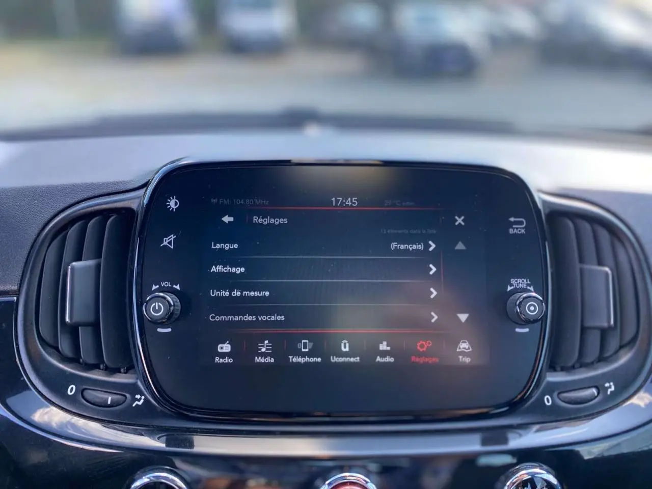 Écran tactile central du tableau de bord de la Fiat 500 noire, affichant le menu des réglages multimédia.