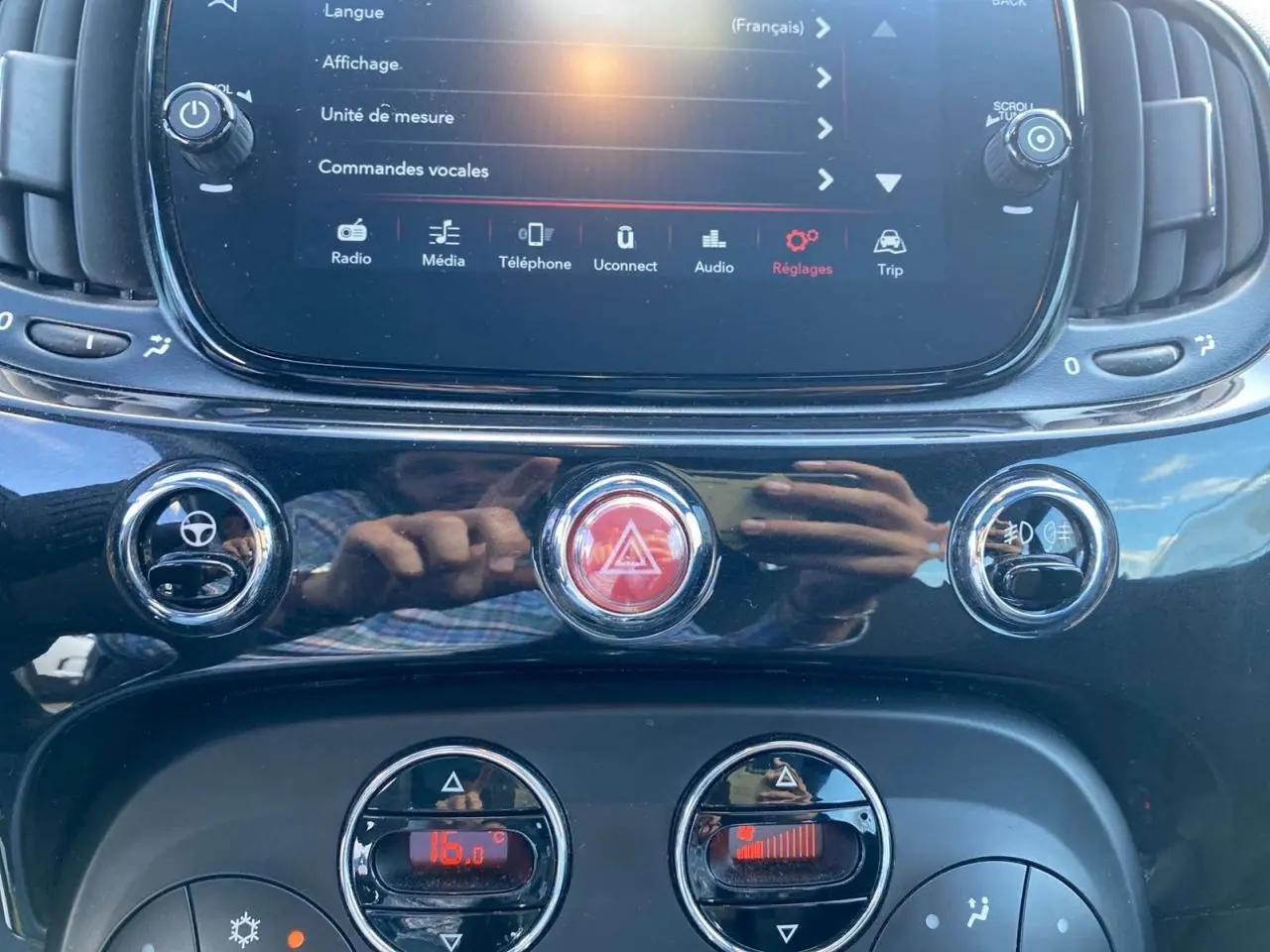 Vue rapprochée de la console centrale noire du Fiat 500 2024, avec écran tactile et commandes climatisation.