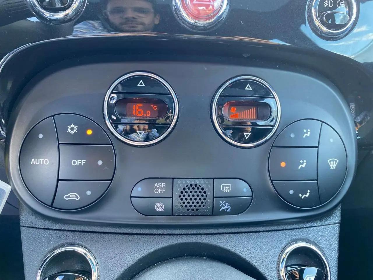 Panneau de commande de climatisation digitale de la Fiat 500 noire, affichant 16°C et réglage de ventilation actif.