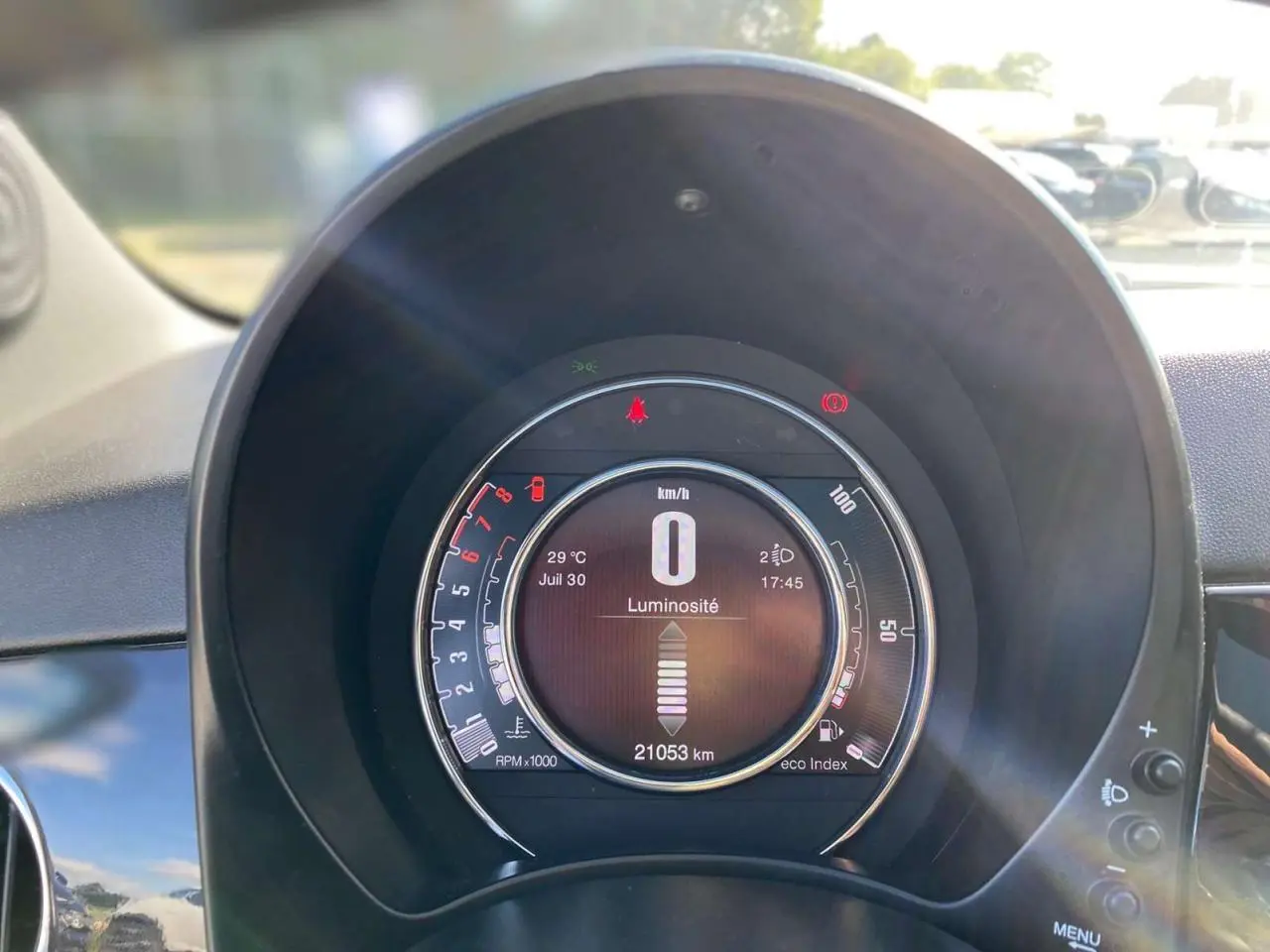 Vue rapprochée du tableau de bord numérique du Fiat 500 noir 2024 affichant la vitesse à zéro et l'odomètre à 21053 km.