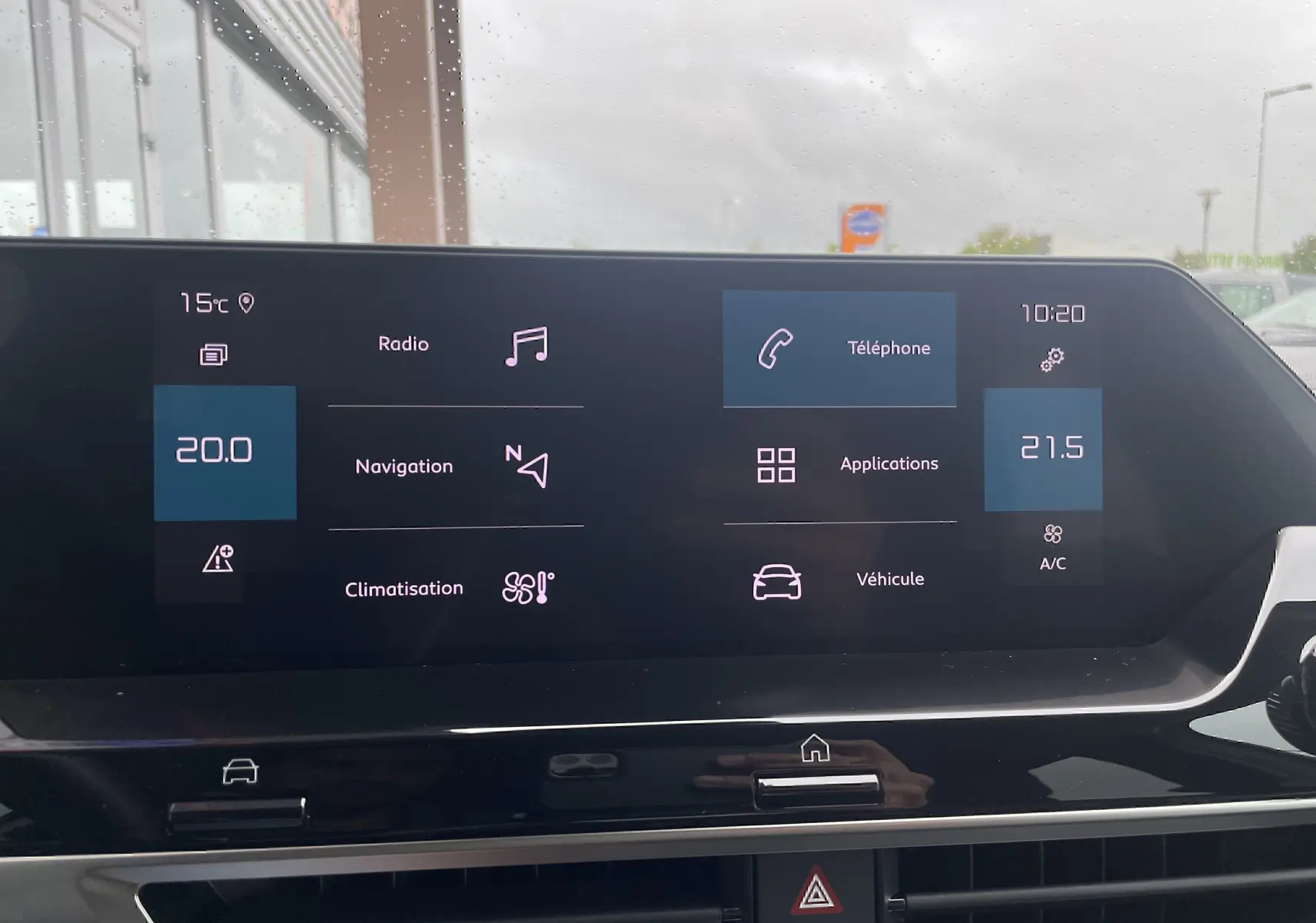 Écran tactile central de la Citroën C4 blanche 2022 affichant radio, navigation, téléphone et climatisation.