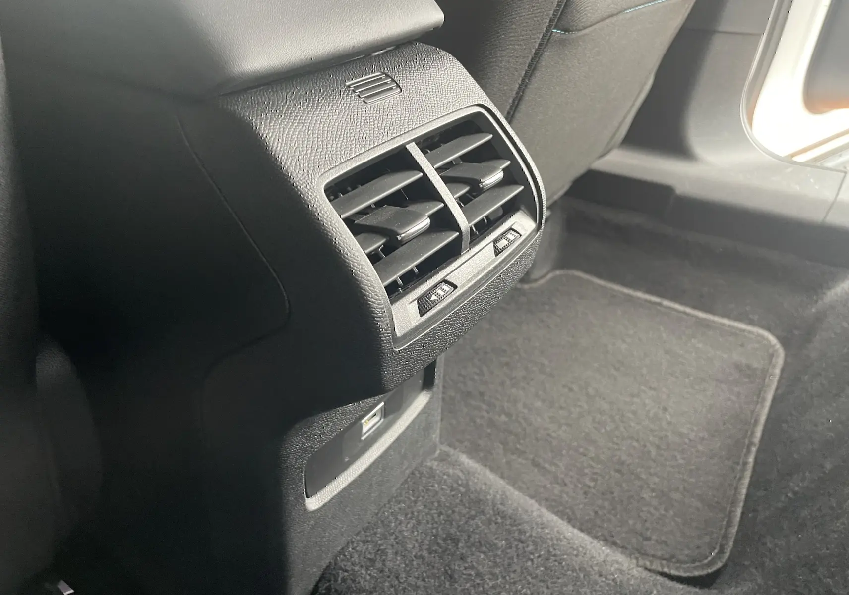 Bouche d'aération arrière noire et port USB dans l'habitacle arrière d'une Citroën C4 blanche 2022.
