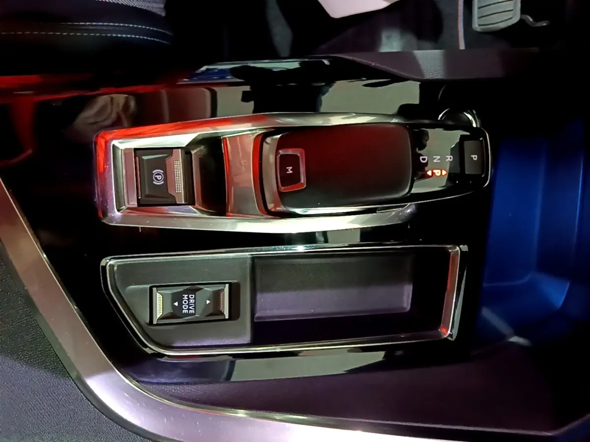 Vue rapprochée de la console centrale noire du Peugeot 3008 2022 avec levier de boîte auto et bouton Drive Mode.